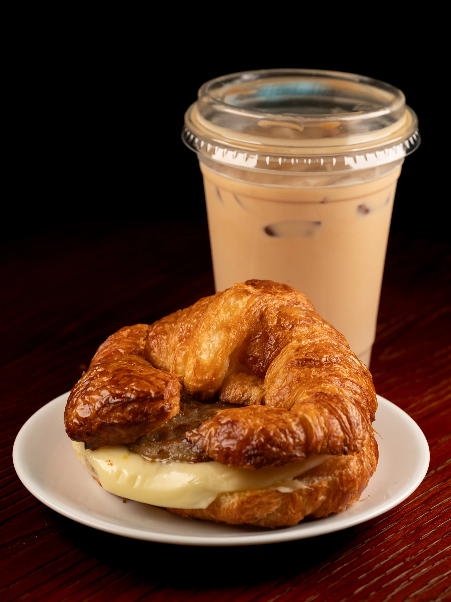 A croissant breakfast sandwich and iced coffee at the café